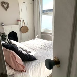 the house in deal holiday cottage main bedroom a view of the room from a partially opened door showing the bed and fireplace