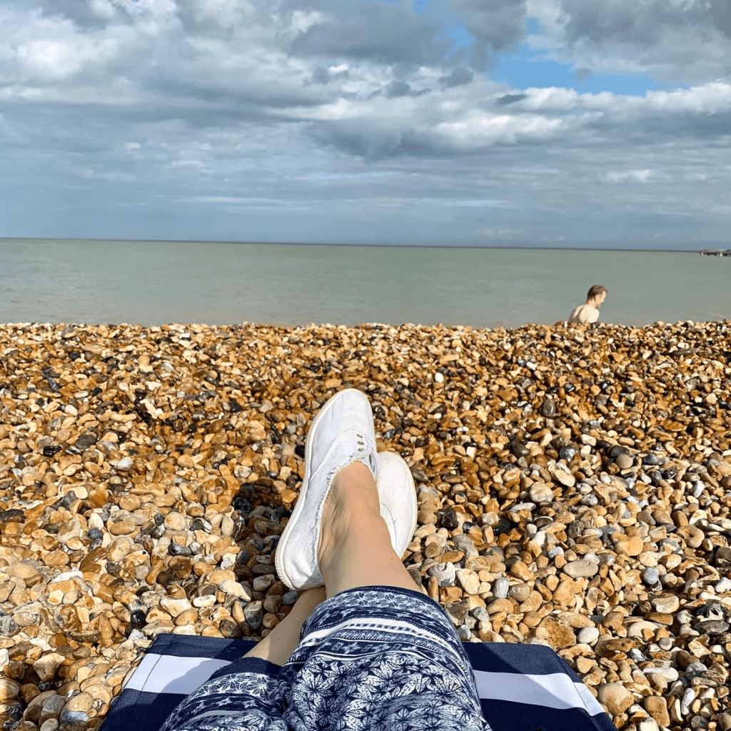 the blue sea of Deal beach taken from the view point of someone sat on the beach, whose feet you can see on white pumps! Shot taken by The house in deal