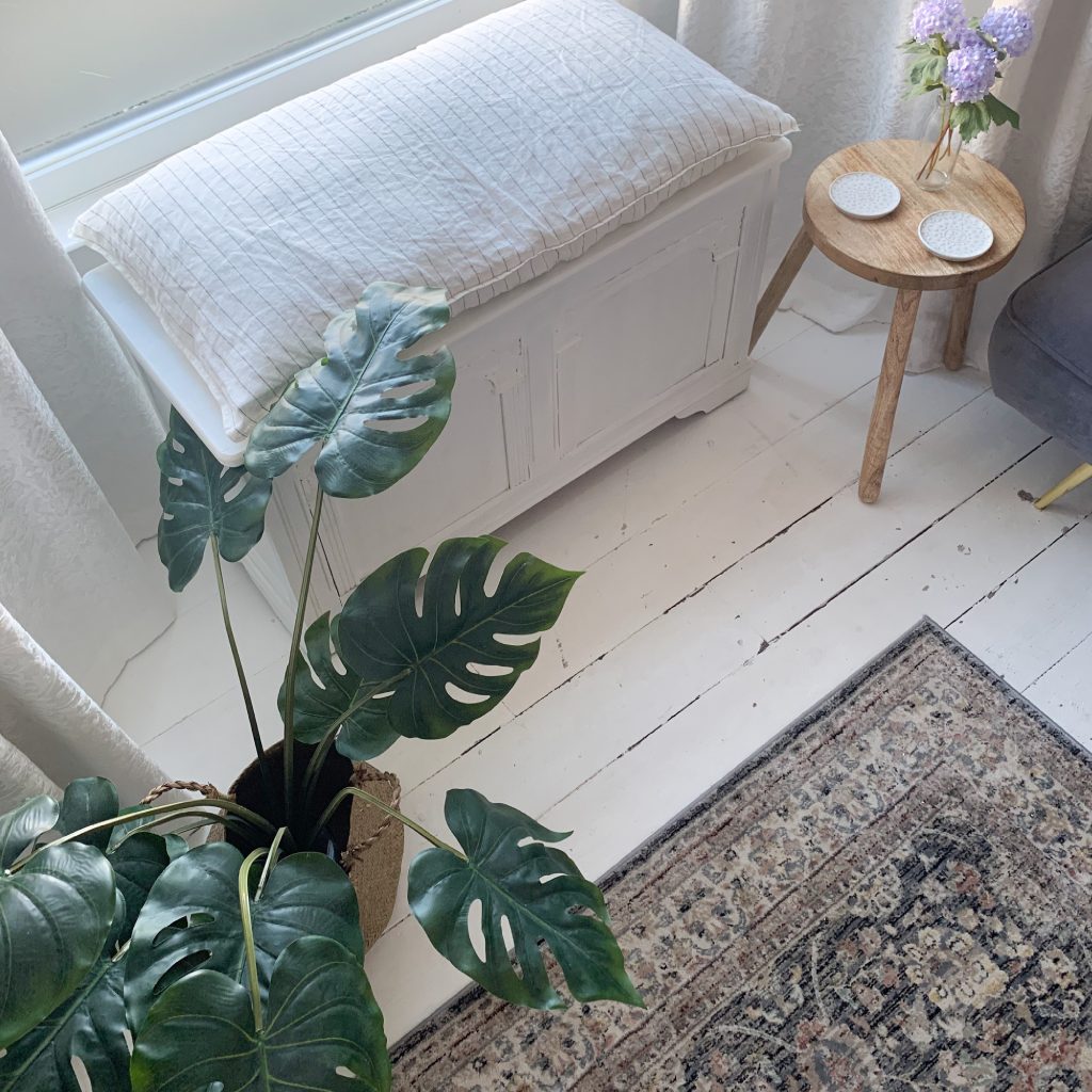 Picture from above of a plant and an old white chest in the sitting room of The House in Deal