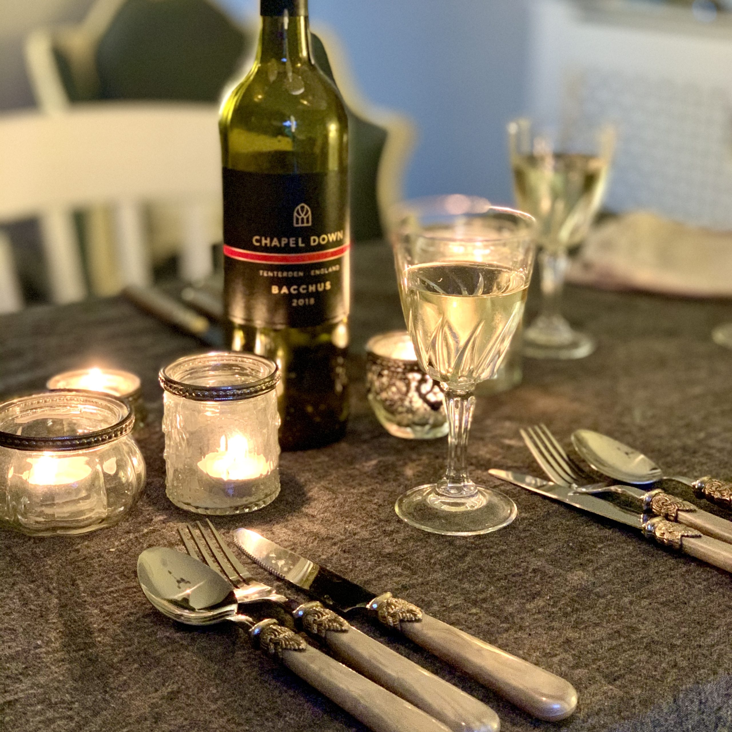 a dinner table set with candles and wine